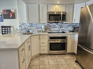 Enjoy cooking in this well-equipped kitchen with a refrigerator, microwave, double oven, and ample counter space.