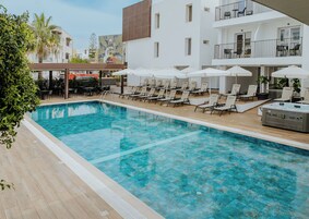 Una piscina al aire libre de temporada, sombrillas