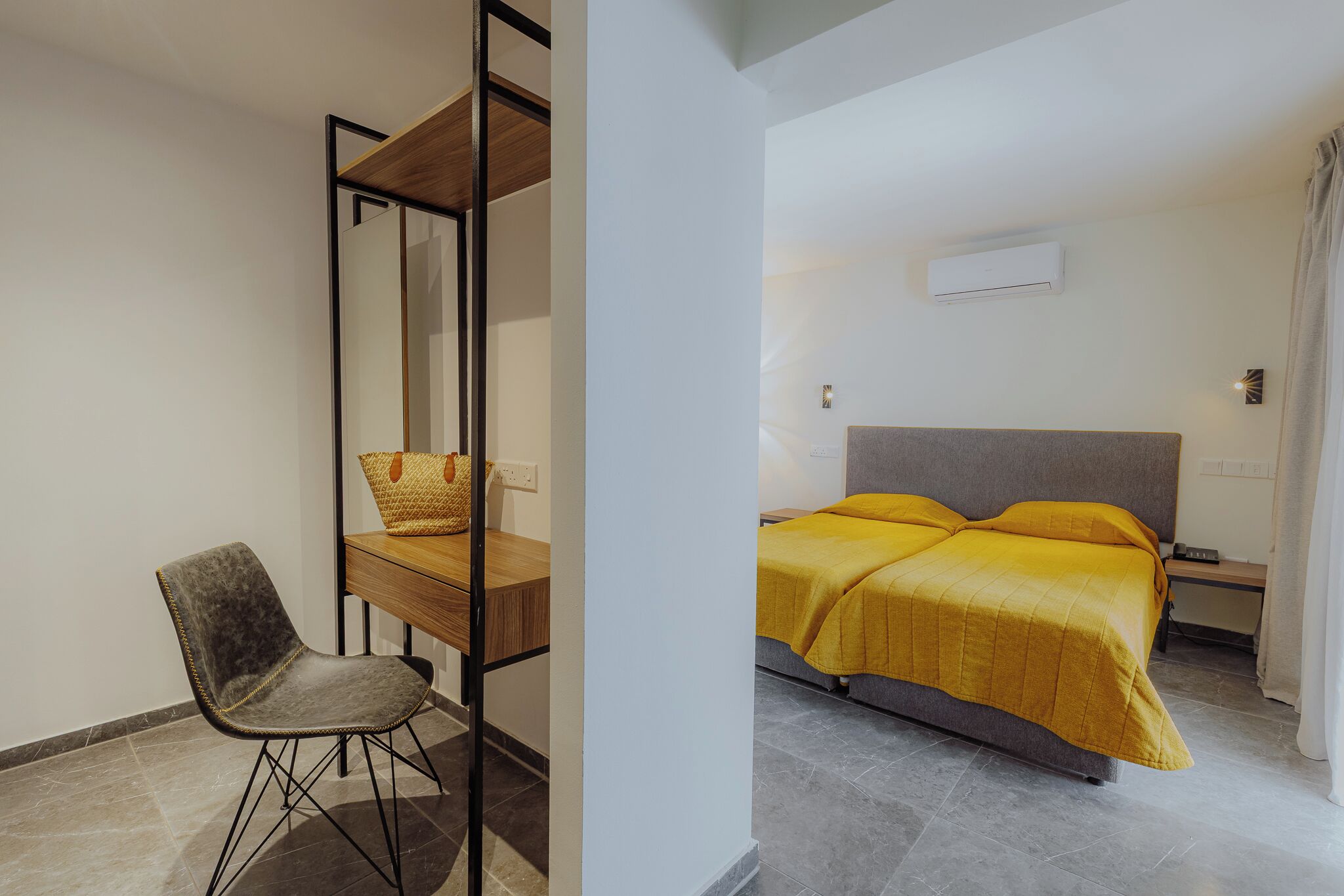 A room with a bed, a desk, and a chair.