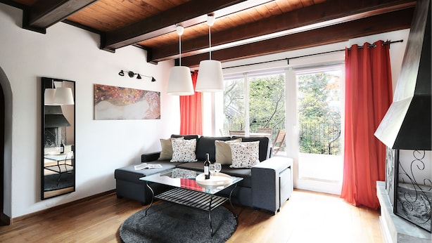Uma sala de estar moderna com um sofá, uma mesa de centro de vidro e uma lareira.