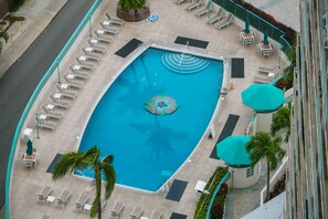An aerial view of a swimming pool with lounge chairs and umbrellas, surrounded by a tiled deck and palm trees. - Free WiFi/No Resort Fees/Oceanview at the Ilikai Hotel!  Beautiful Sunset Views! (Honolulu)