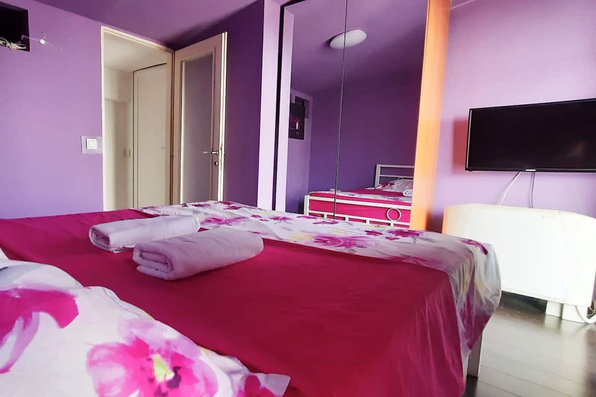 Ein Schlafzimmer mit Bett, Fernseher und Kleiderschrank.