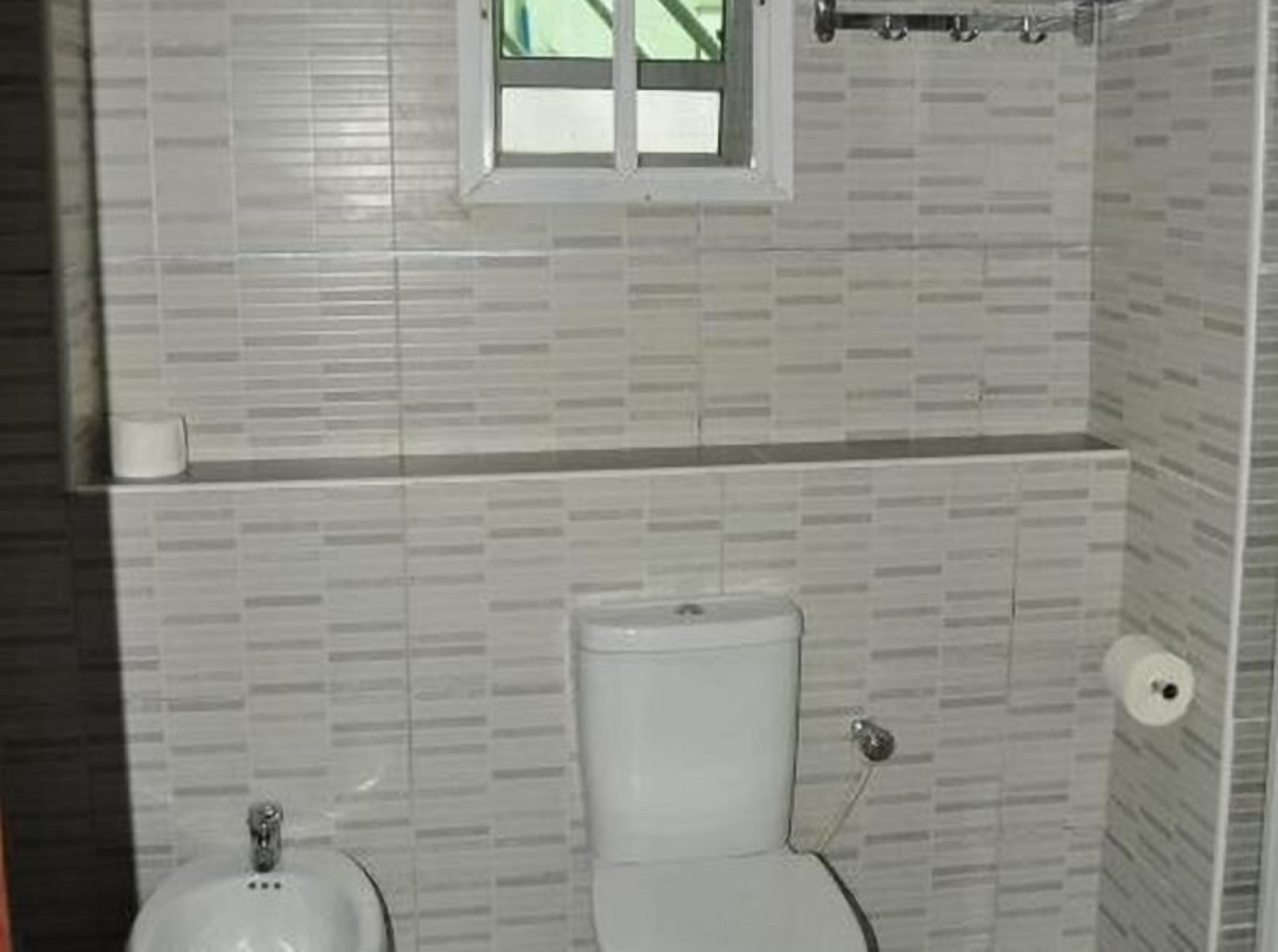 Une salle de bain avec des toilettes, un bidet et une fenêtre.