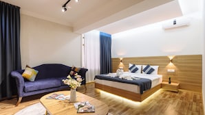 Une chambre d’hôtel moderne équipée d’un lit, d’un canapé, d’une table basse et d’une table de chevet.