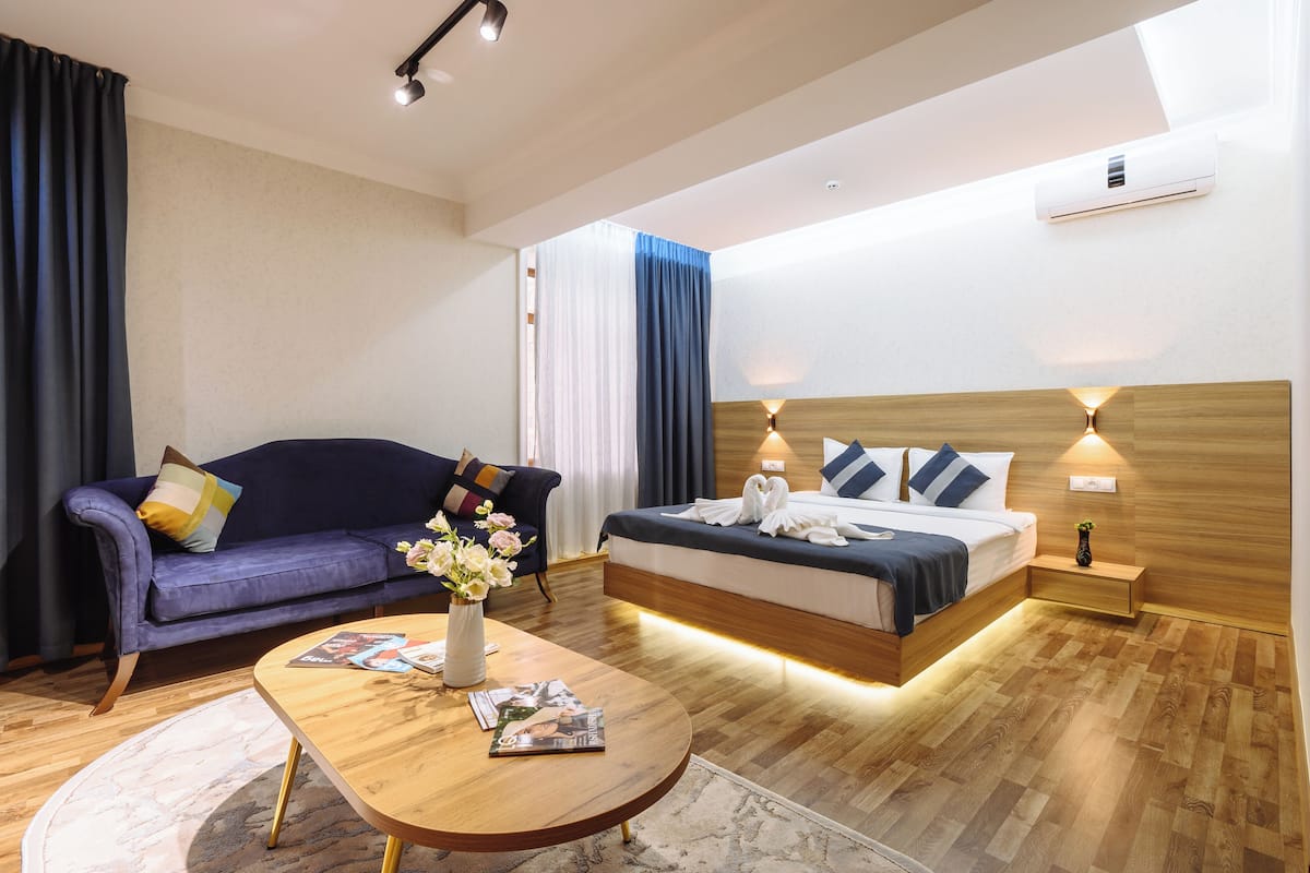 Une chambre d’hôtel moderne équipée d’un lit, d’un canapé, d’une table basse et d’une table de chevet.