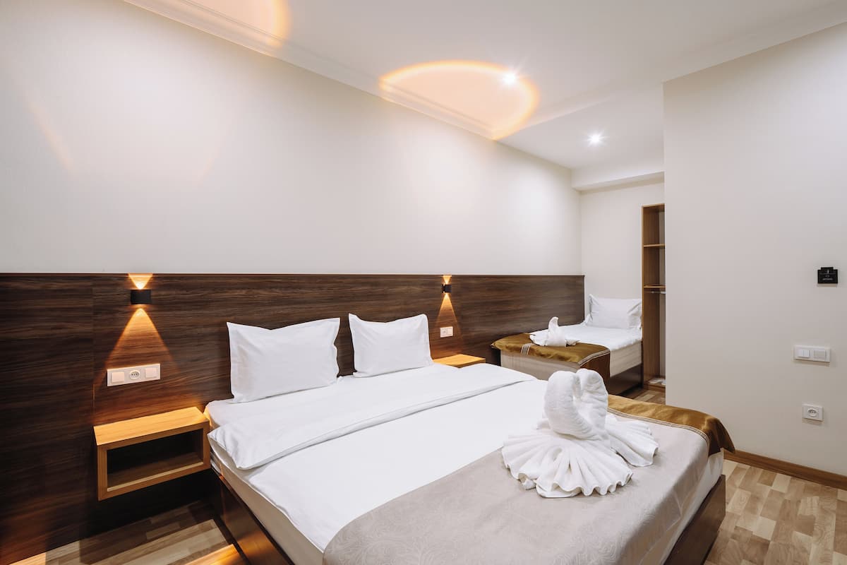Une chambre d’hôtel avec un grand lit, des tables de chevet, une armoire et une salle de bain.