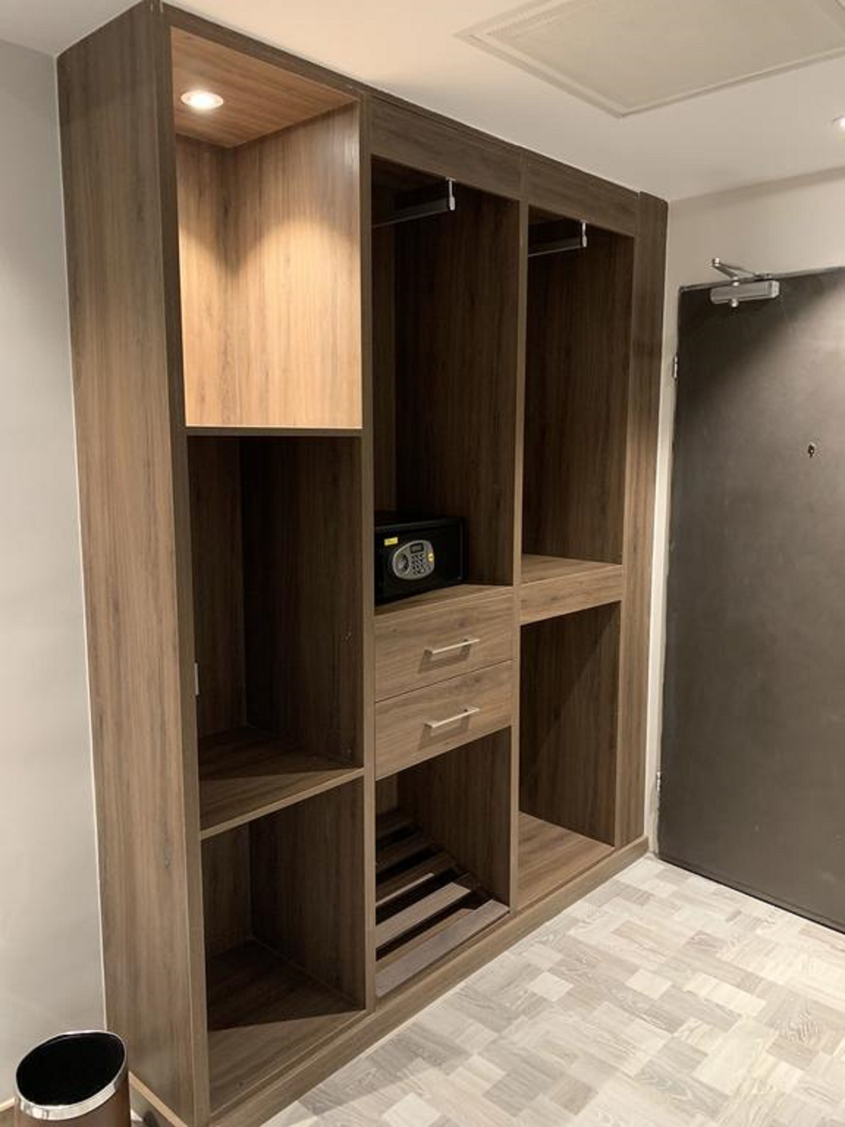 A walk-in closet with wooden shelving, a radio, and a door.