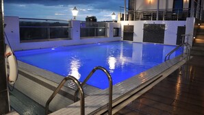 A swimming pool with a clear view of the sky, a lifebuoy, and a metal ladder. - Taidy's Suites - Nakuru (Nakuru)