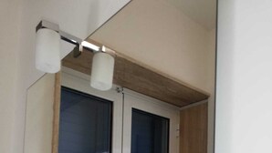 A room with a window, a door, and a light fixture above the window. - Coast to coast Salento sea rooms (Porto Cesareo)