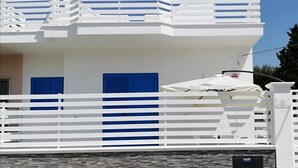 A white building with blue shutters, a white balcony, and a white fence. - Coast to coast Salento sea rooms (Porto Cesareo)
