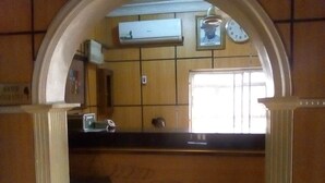 A reception area with a tiled wall, a clock, and a framed picture.