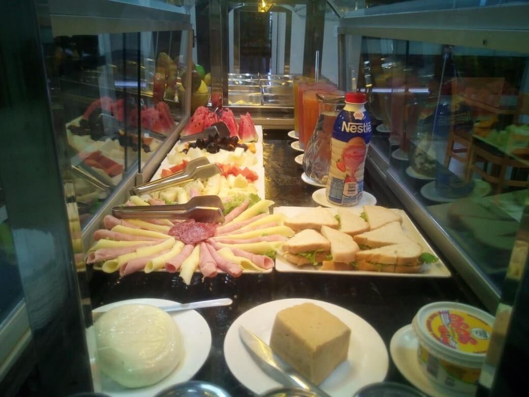 A buffet with various food items including pasta, sandwiches, and a bottle of Nestlé ice cream.