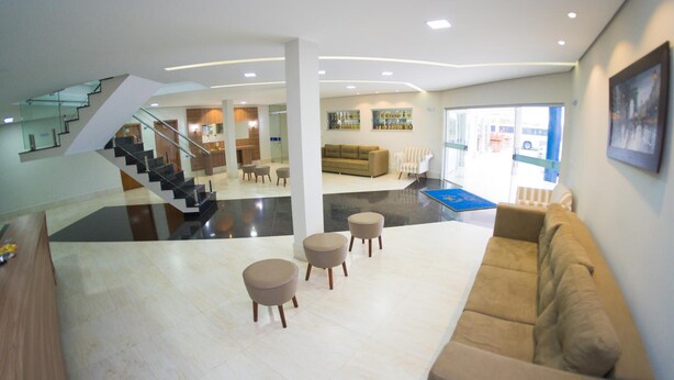 A spacious lobby with a staircase, a sofa, and a coffee table.