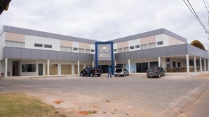 A hotel with a central entrance, multiple parking spaces, and a paved driveway.