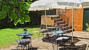 A patio with outdoor seating, a staircase, and a covered area.