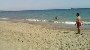 A sandy beach with a clear sky and calm sea.