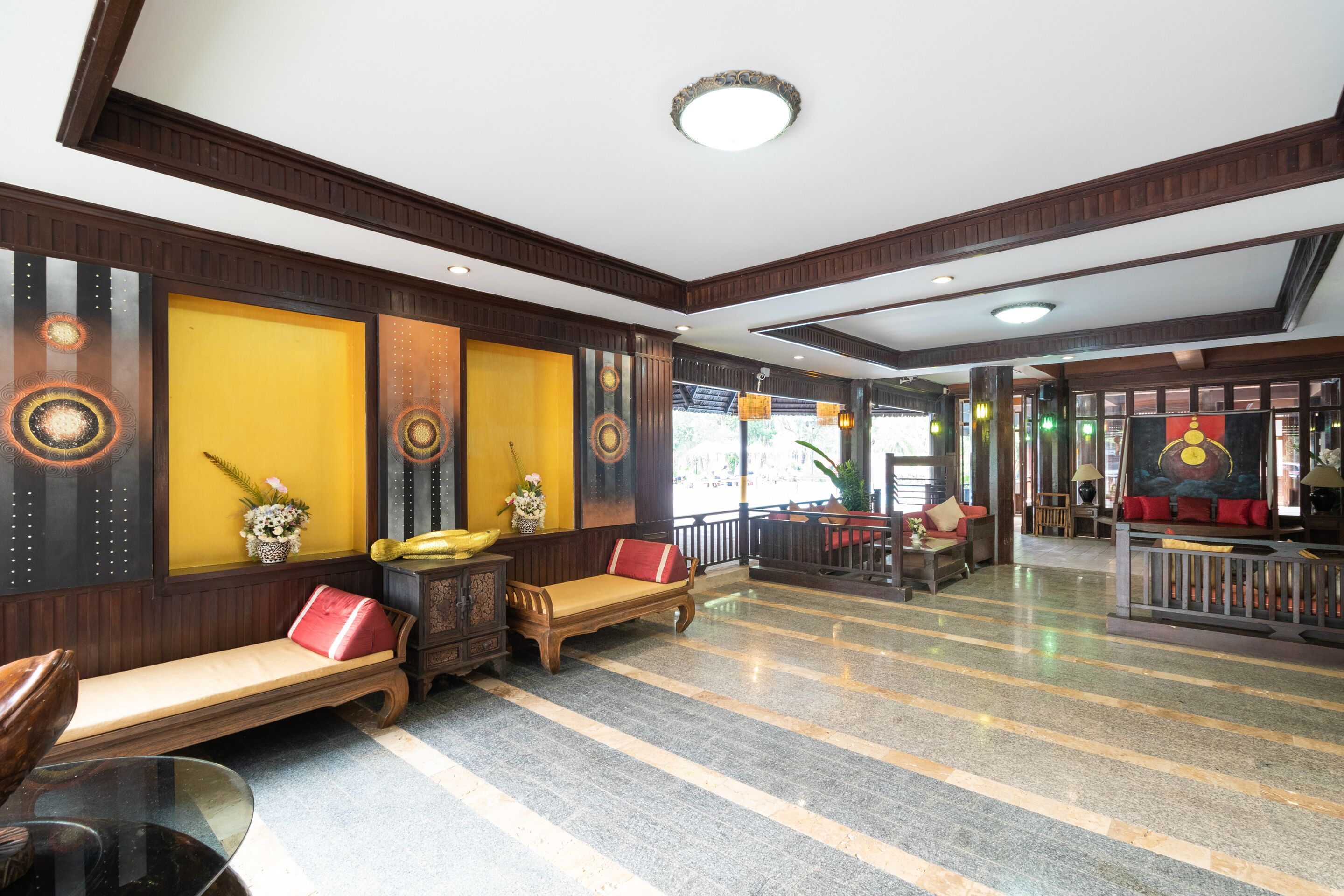 En rummelig lobby med et marmorgulv, træbænke og et receptionområde med et klassisk design.