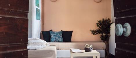 A cozy room with a sofa, a small table, and a potted plant.