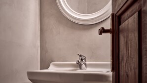 A bathroom with a sink, a mirror, and a door.