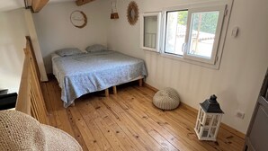 A bedroom with a wooden floor, a bed, a window, and a lantern. - Villa with terrace 200m from the beach (Six-Fours-les-Plages)