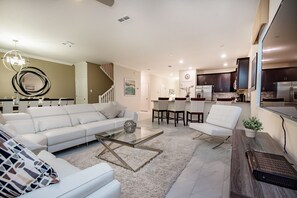 Relax in a stylish living room with a leather sofa, coffee table, and armchair, plus a dining area and kitchen.