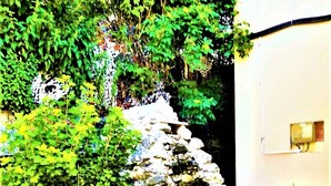A stone staircase leading up to a stone wall with a potted plant at the bottom. - Hotel House Bran (Busteni)