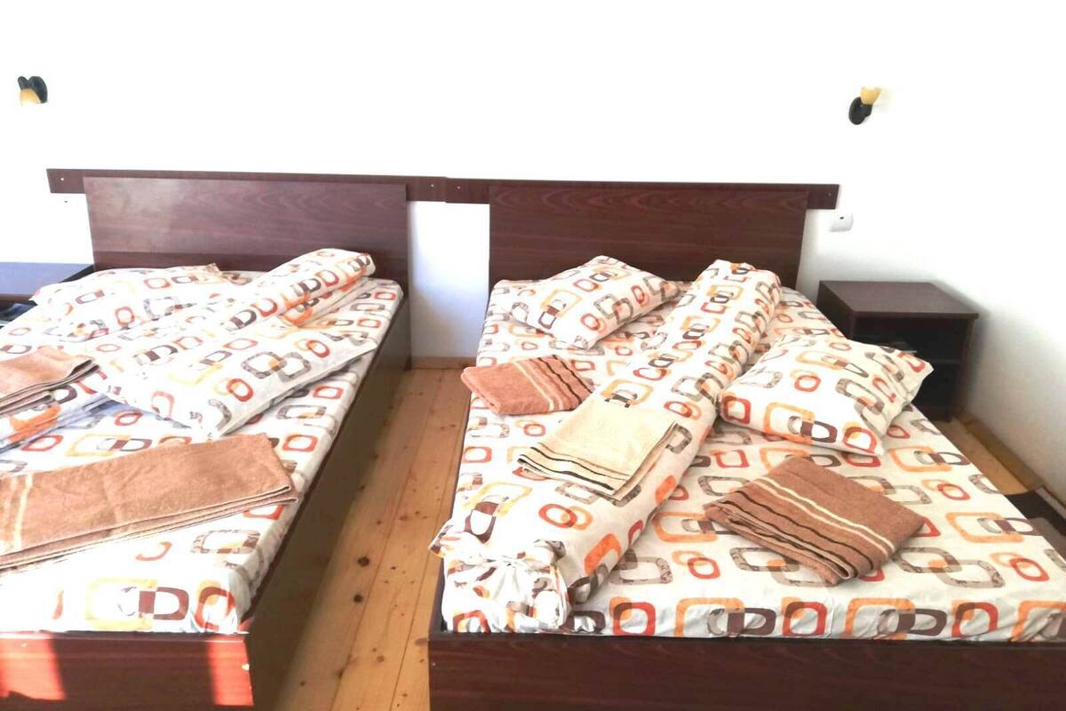 A double bed with patterned bedding and a wooden headboard.