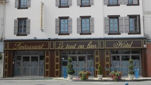 A building with a restaurant and hotel on the ground floor, featuring a classic facade with shutters and a sign reading "Le tout va bien." - Hotel Restaurant Le Tout Va Bien (Valence)