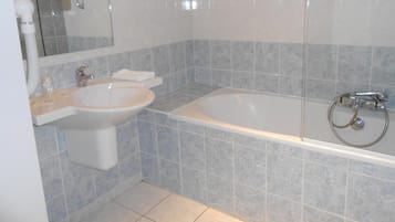 Een badkamer met een wastafel, spiegel en bad.
