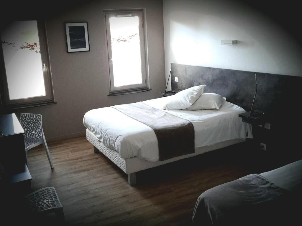 A bedroom with a bed, bedside table, lamp, and a window.