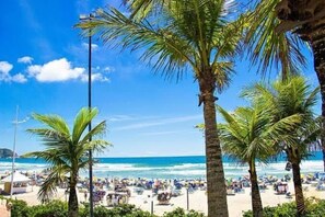 Una playa con palmeras y una multitud de gente.