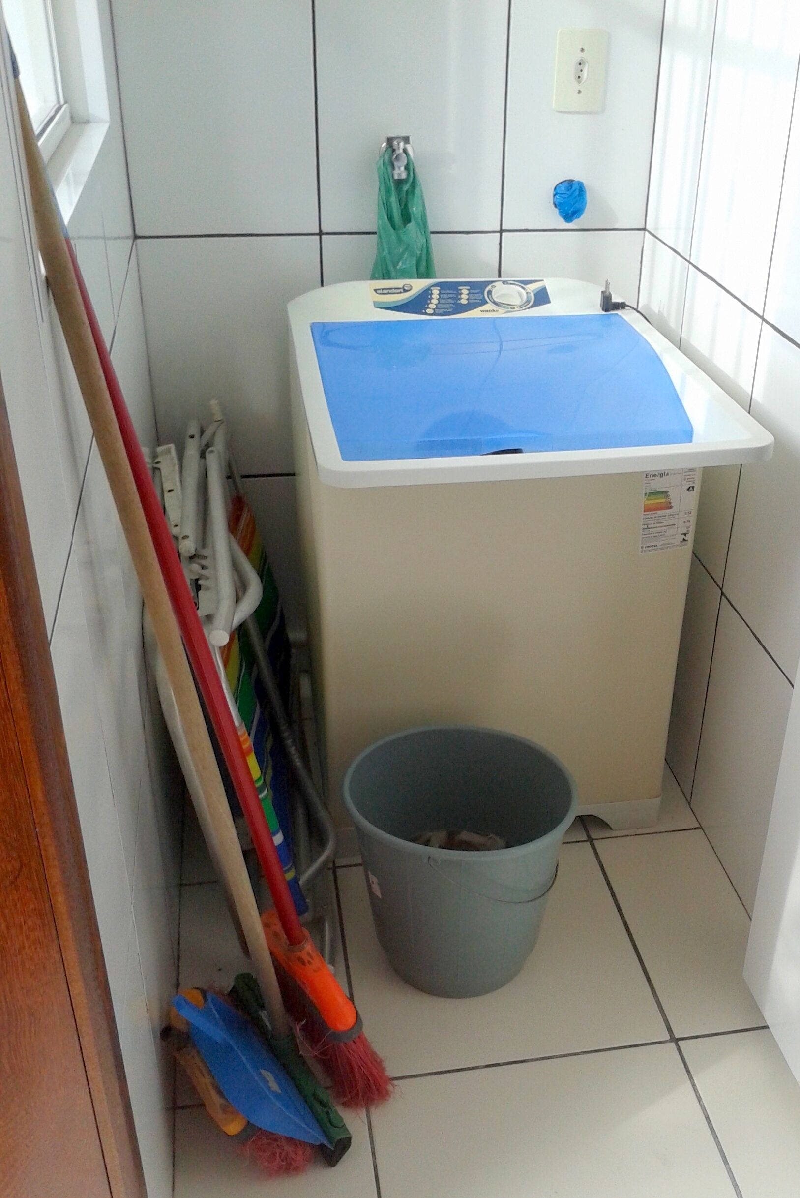 A small bathroom with a sink, a bucket, and cleaning tools.