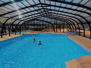 Una piscina cubierta, una piscina al aire libre de temporada, tumbonas