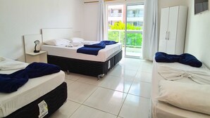 A hotel room with two beds, a wardrobe, a window with curtains, and a ceiling light. - Maresia Unique (Ipojuca)