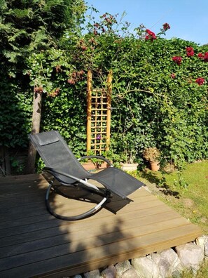 A wooden deck with a single lounge chair. - 4 star basement apartment Alt-Mariendorf (parking lot on the property) (Bezirk Tempelhof-Schöneberg)