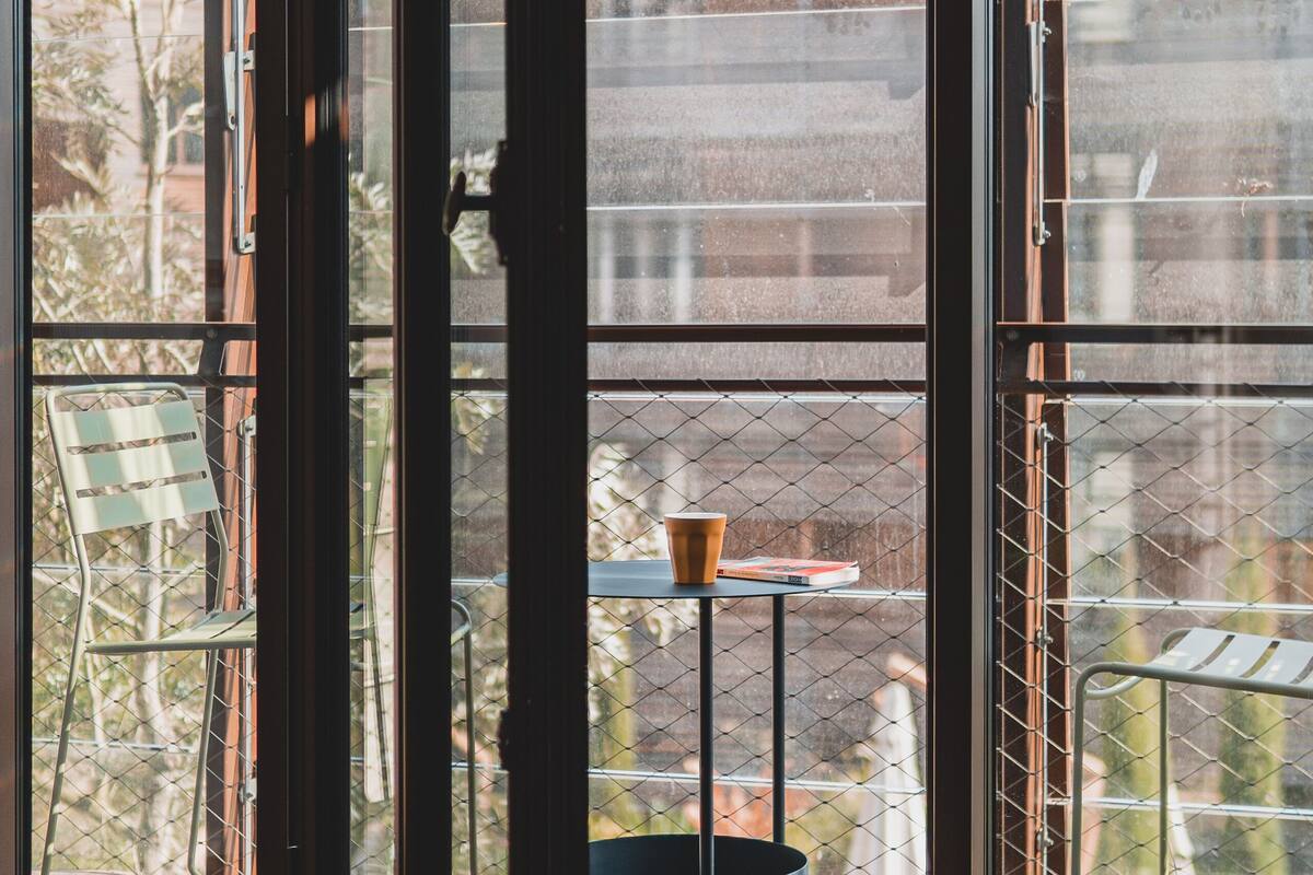 Een kamer met grote glazen deuren die uitkomen op een terras.