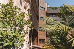 Ein mehrstöckiges Gebäude mit einer Mischung aus moderner und traditioneller Architektur, mit Balkonen und großen Fenstern.