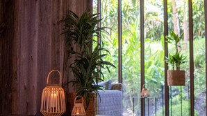 Una zona de piscina con detalles de madera, plantas en macetas y faroles de mimbre.