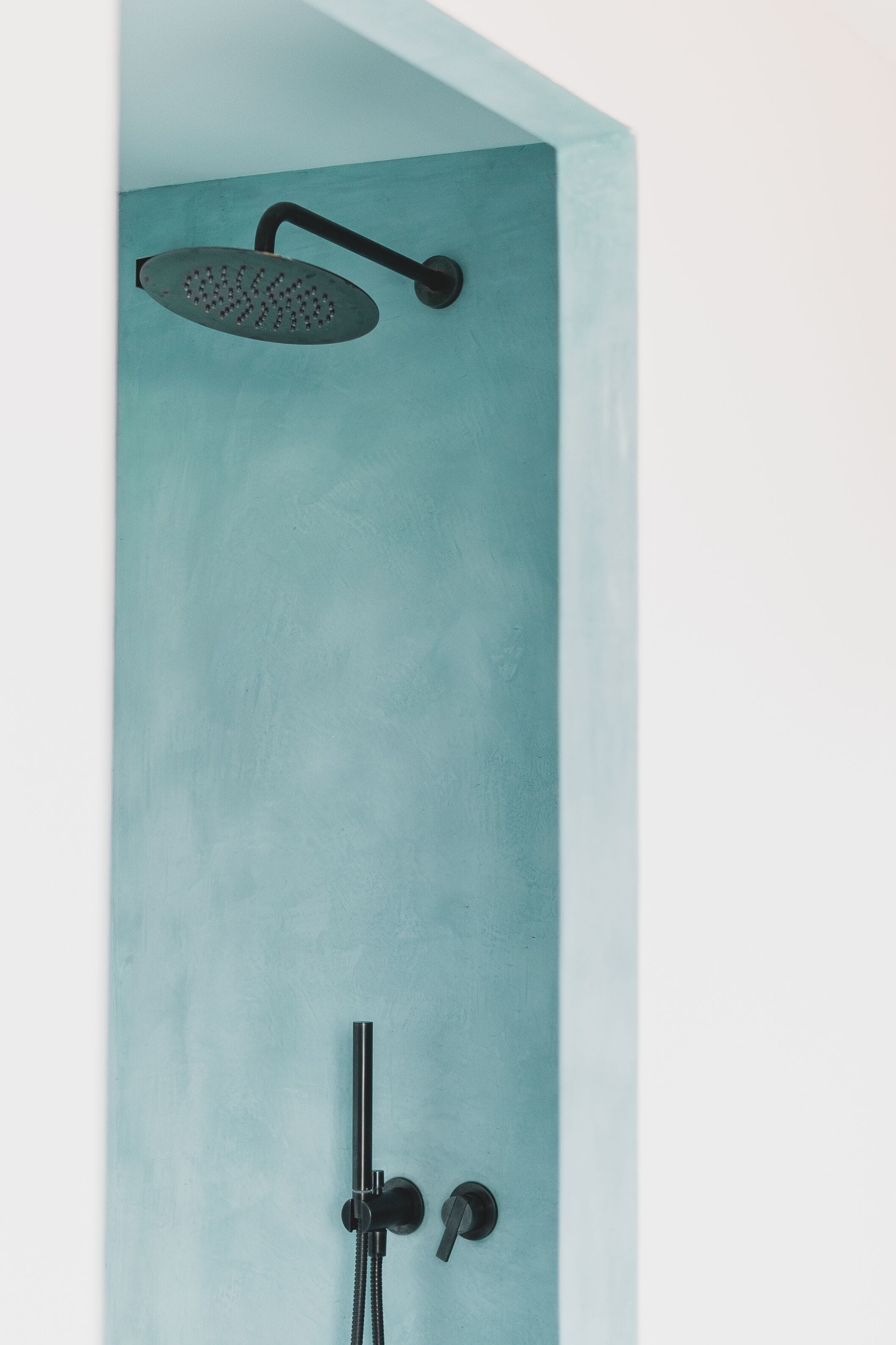 Een badkamer met een enkele douchekop en een handdouche.