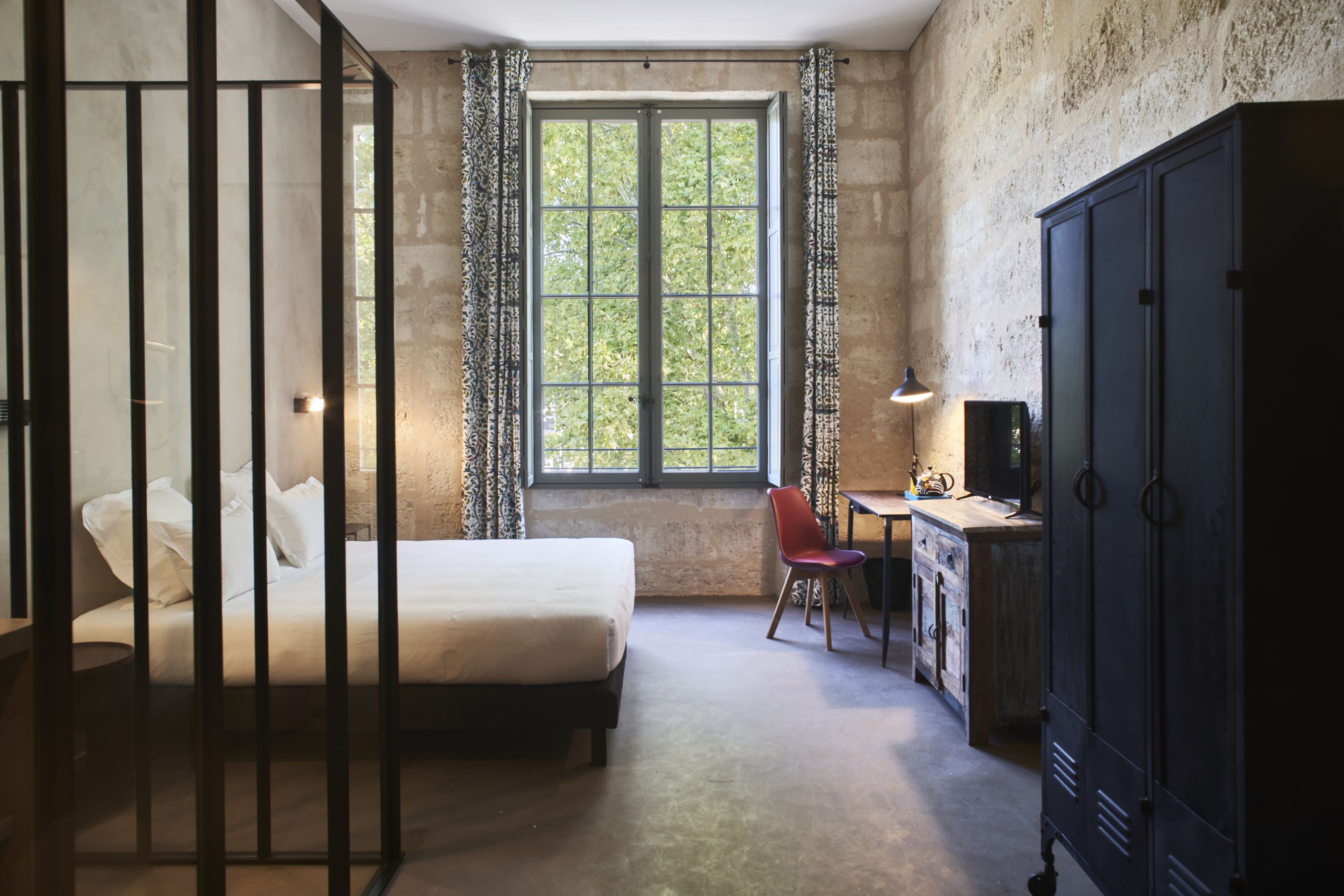 Ein Schlafzimmer mit einem Bett, einem Schreibtisch, einem Stuhl und einem Kleiderschrank.