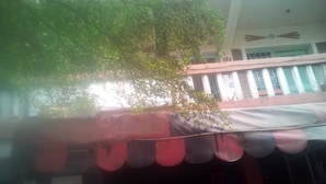 A building with a red awning and a tree in front. - Diamond Guest House (Nairobi)