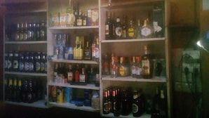 A bar area with shelves stocked with various liquor bottles. - Diamond Guest House (Nairobi)
