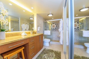 A modern bathroom with a large mirror, a sink, and a shower area.
