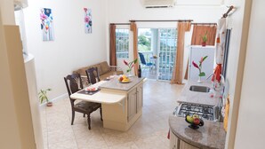 A kitchen with a dining area, a gas stove, a sink, and a view of the outdoors. - Affordable, Majestic, St. Lucia Jazz and Carnival, Bay View Apartment (Castries)
