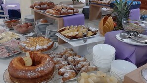 Una mesa de buffet con diferentes opciones de comida, incluyendo pasteles, frutas y un refrigerador de Coca-Cola.
