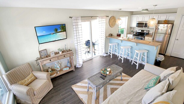 A modern living room with a sofa, a coffee table, and a TV. - Star Gaze on your Private Second Level Deck! (Ottawa)