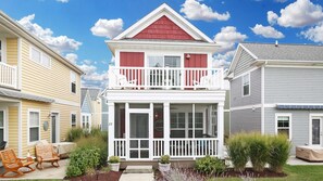 A two-story house with a balcony, a front porch, and a small garden area. - An Inviting Retreat! (Ottawa)