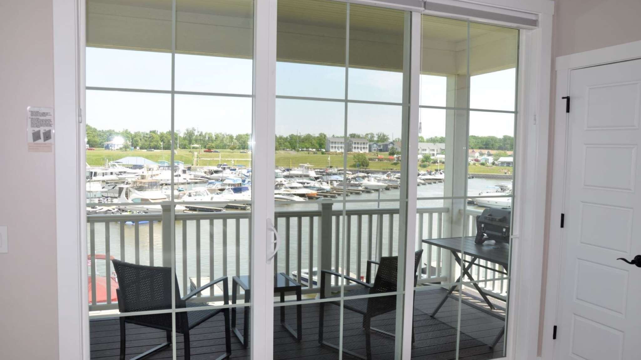 Un balcon donnant sur une marina, avec une table et deux chaises.