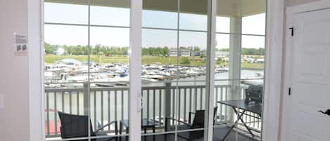 Un balcon donnant sur une marina, avec une table et deux chaises.