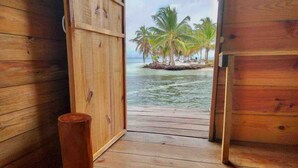 A wooden deck leading to a beach with palm trees. -  Paradise Over the Water Cabins in San Blas (Narganá)